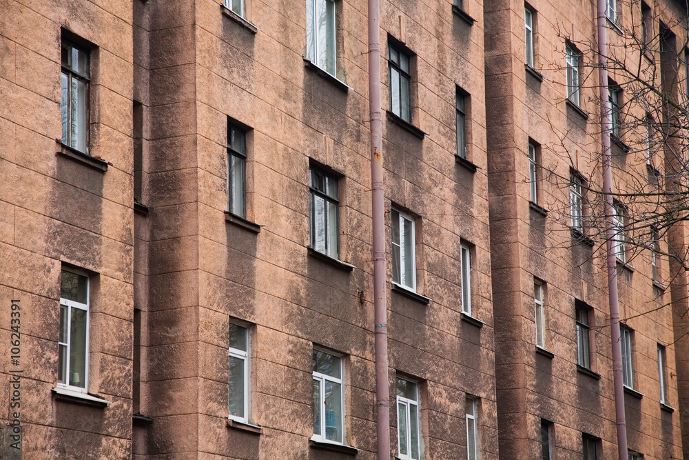 Fototapeta premium Facade of a multi-storey old house with windows