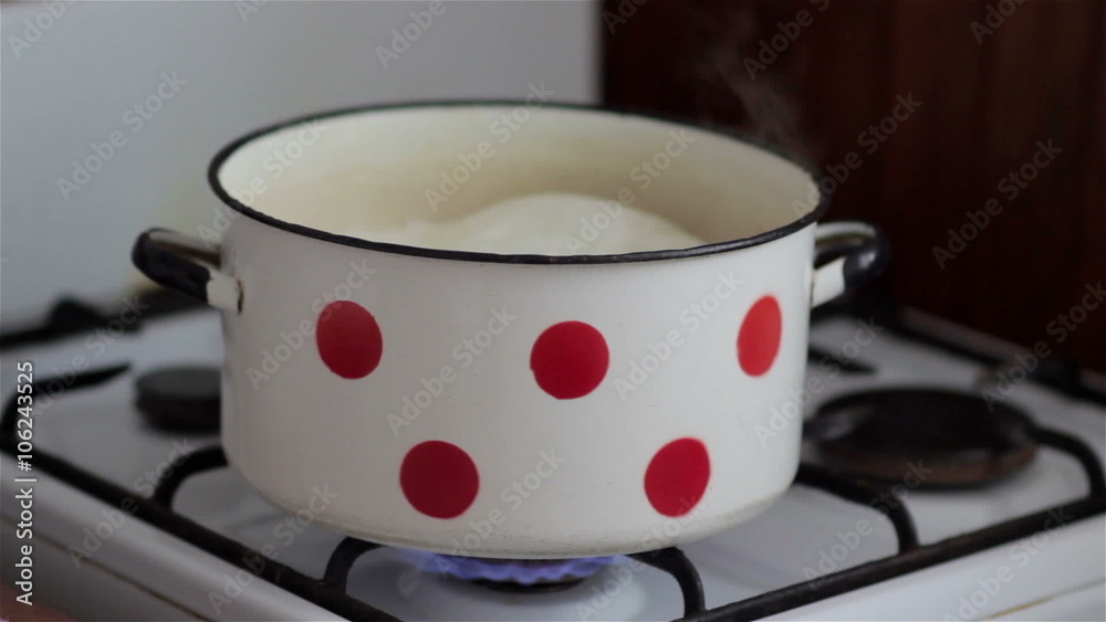 boiling milk/on a gas stove boiling milk in a saucepan on the stove and