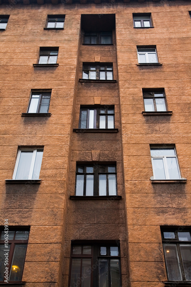 Fototapeta premium Facade of a multi-storey old house with windows
