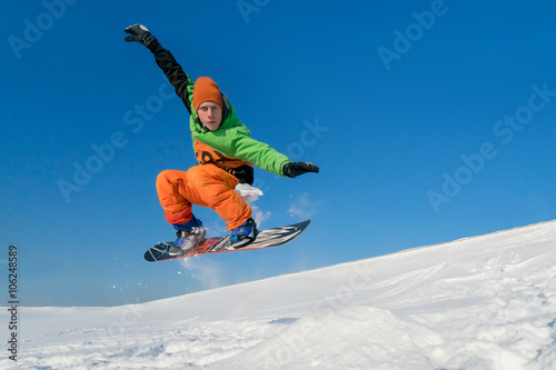 Snowboarder jumping blue sky in background