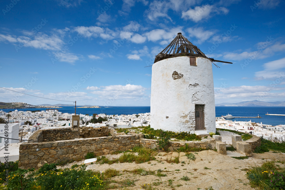 Old traditional windmill and town of Mykonos in Cyclades, Greece.
