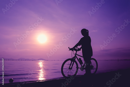Silhouette of healthy biker-girl enjoying the view at seaside