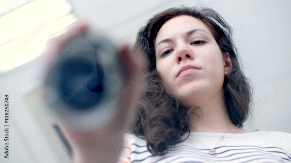 Beautiful young girl puts print stamp on office glass table. shoot from below