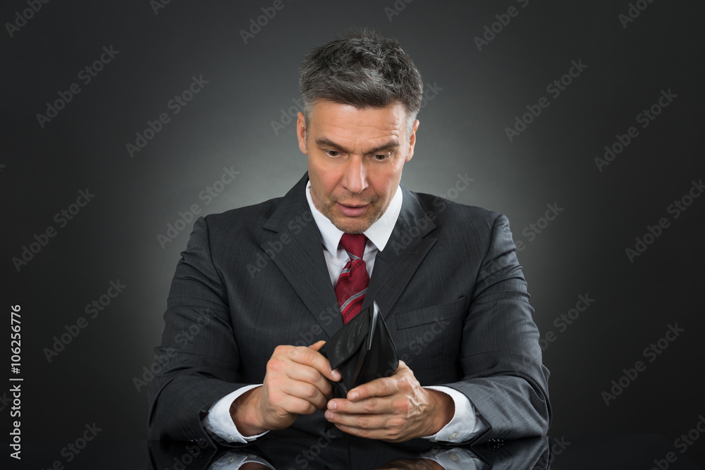 Businessman With Empty Wallet Sitting At Desk Businessman With Empty Wallet Sitting At Desk