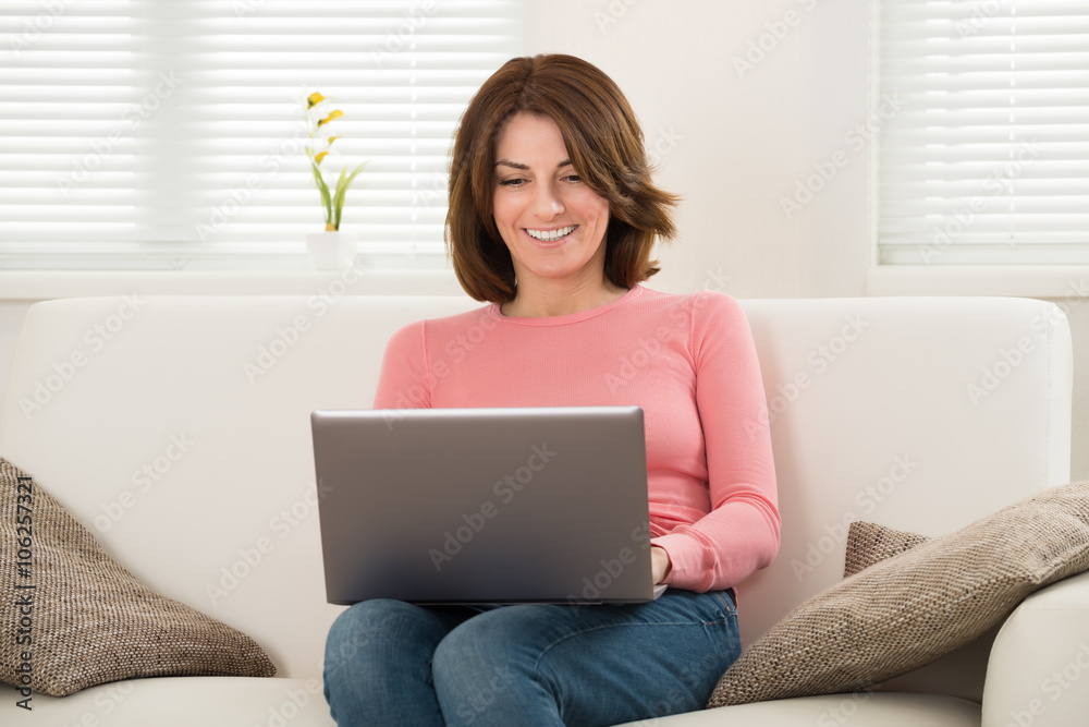 Woman Sitting On Sofa Using Laptop Woman Sitting On Sofa Using Laptop