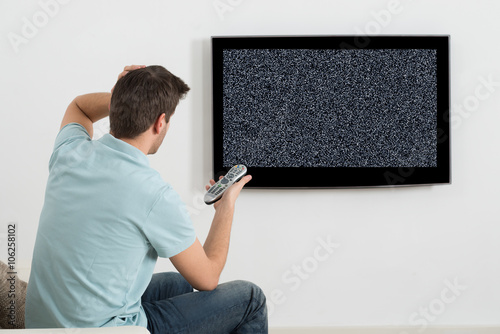 Man Sitting On Sofa In Front Of Television