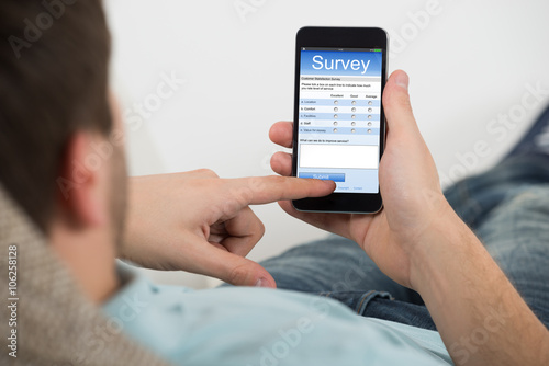 Man Filling Online Survey Form On Mobile Phone