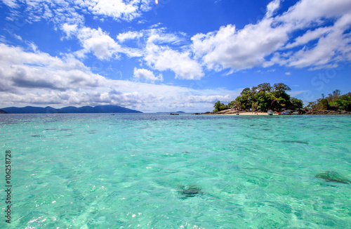 Clear sea water and blue sky with clouds