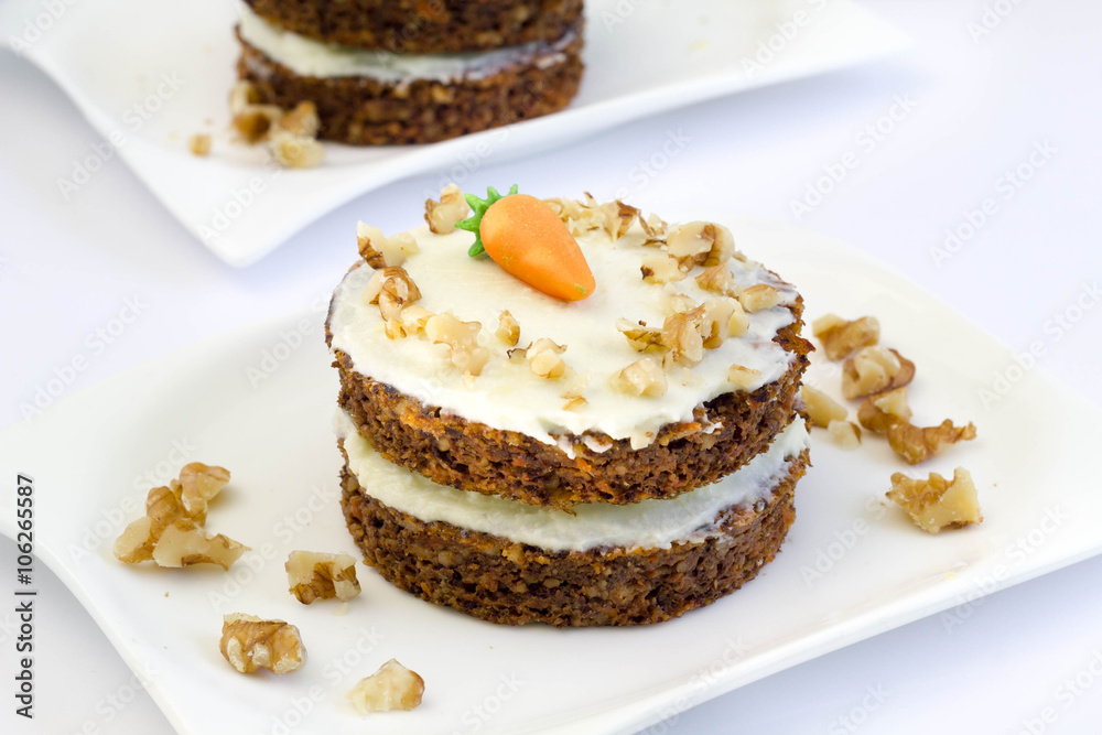 Round mini carrot cakes with cream cheese frosting and marzipan carrot on top.