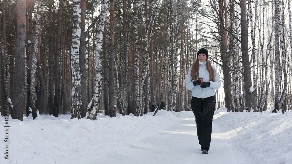 Happy smiling woman with cup of hot coffee or tea outdoors in winter in forest Happy smiling woman with cup of hot coffee or tea outdoors in winter in forest