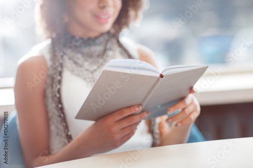 Pleasant girl reading book