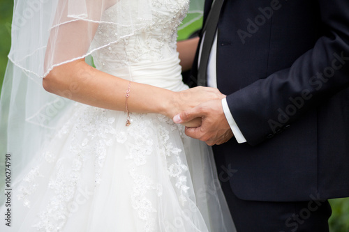 Close up shot of groom and bride holding hands and huging outdoors © marinegirl