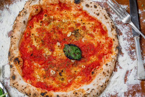 Quadro su tela Traditional italian pizza with tomato sauce, garlic and basil, o