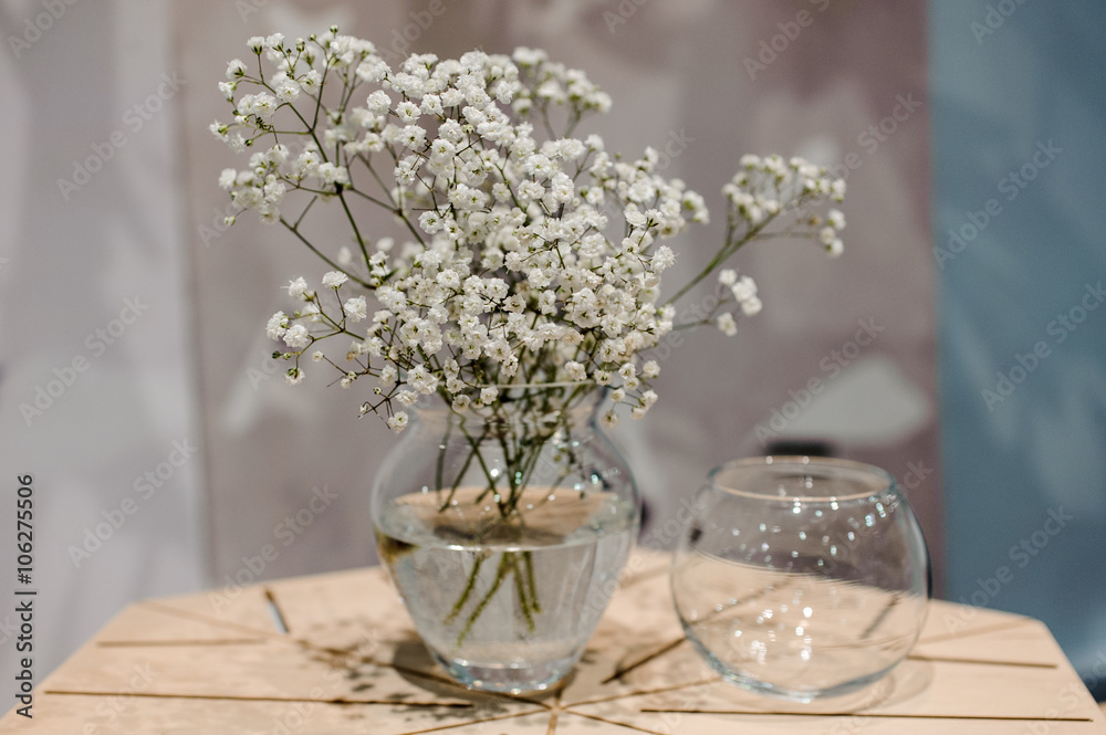 Fototapeta premium Vase with bunch of Gypsophila Baby's-breath flowers on wooden table