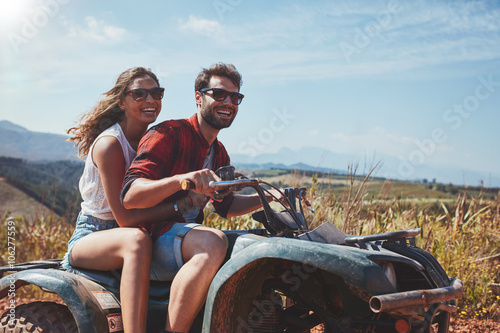 Happy young couple driving a quad bike photo