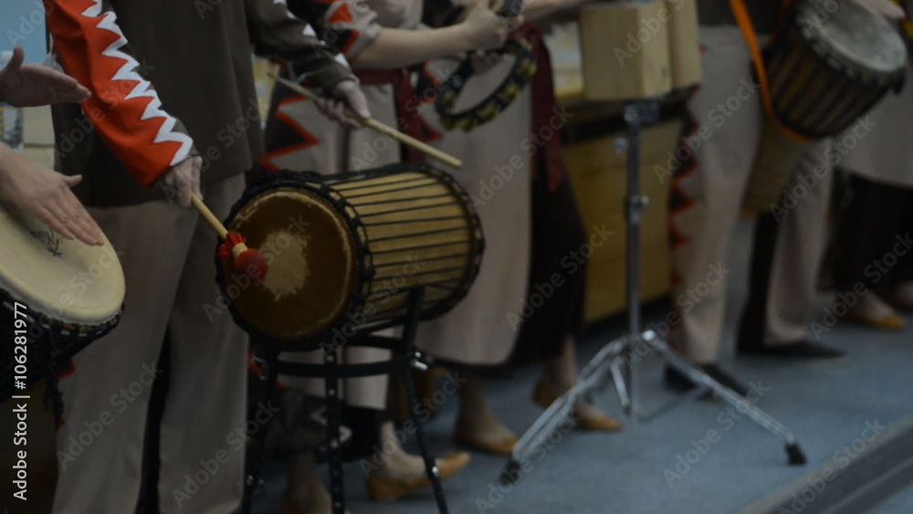 A group of people in costumes playing the African drums
