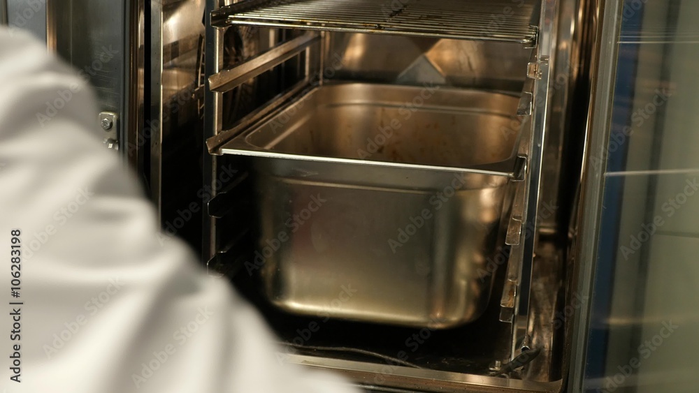 Putting food in a Professional oven in a restaurant kitchen Putting food in a Professional oven in a restaurant kitchen