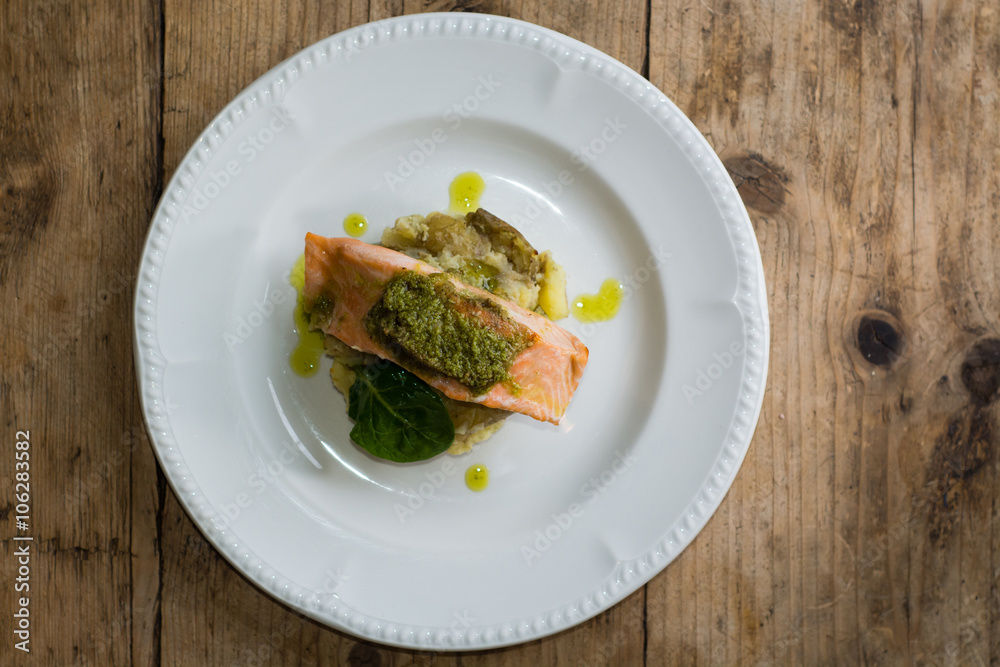 Salmon fillet, pesto and crushed potato from above. A restaurant prepared fish dish presented on a white plate
Salmon fillet, pesto and crushed potato from above. A restaurant prepared fish dish presented on a white plate
