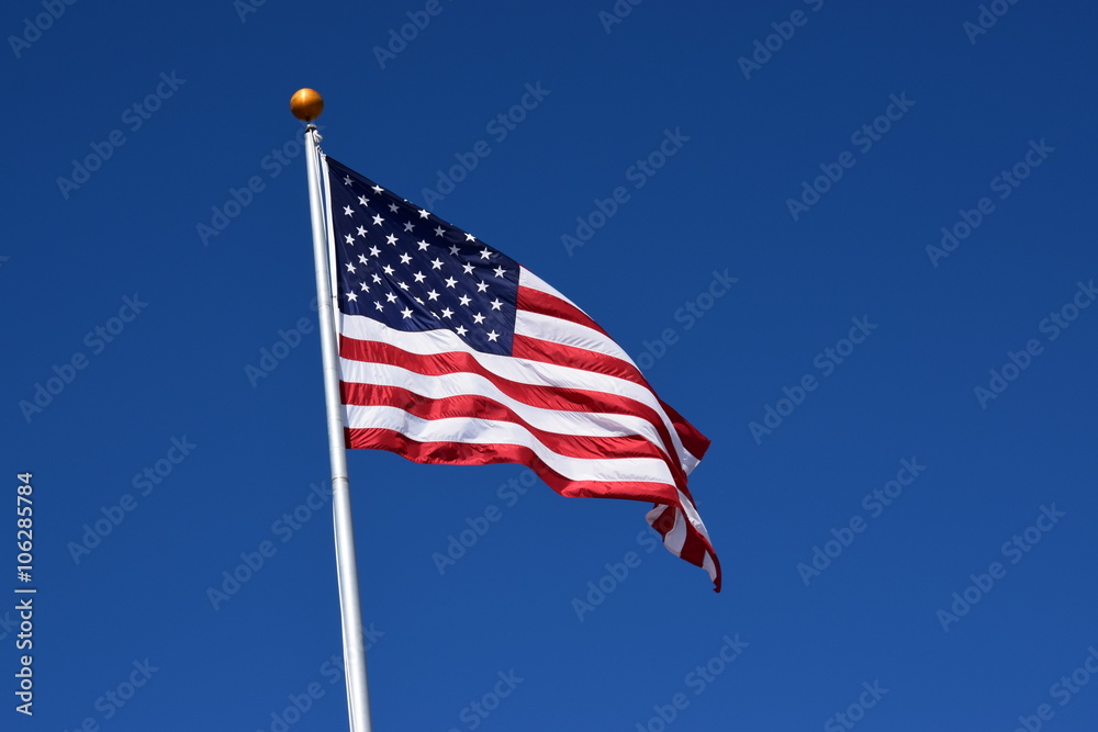 Fototapeta premium American flag waving in a clear blue sky