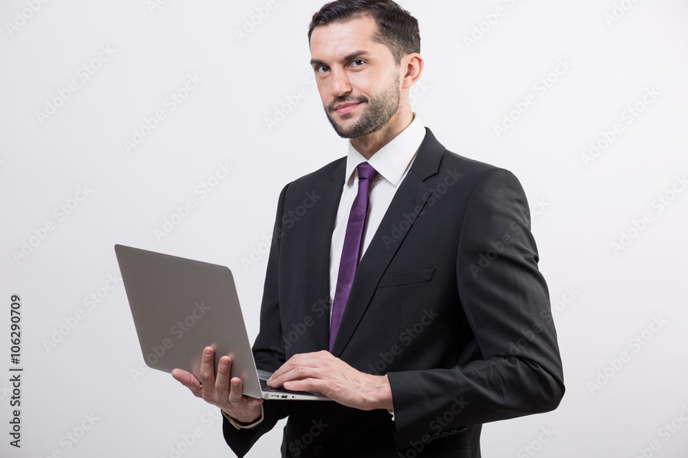 Young business man with a laptop in a studio Young business man with a laptop in a studio