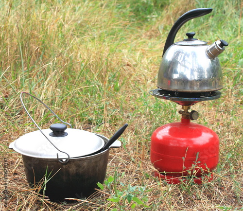 Cauldron, kettle and gas primus in summer on the grass