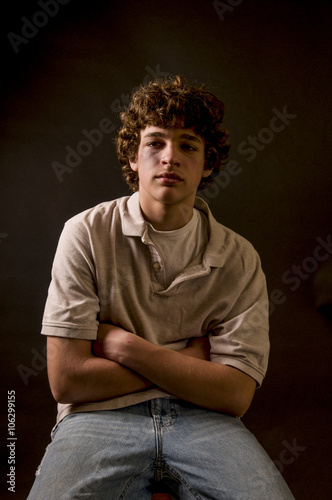 Moody shot of battered, lonely teenage boy