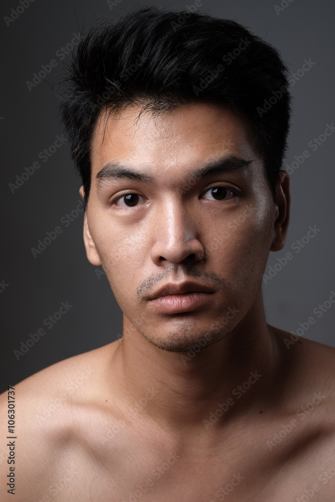 Asian man portrait with no makeup show his real skin in grey background - soft focus Asian man portrait with no makeup show his real skin in grey background - soft focus