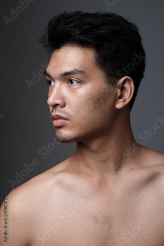 Asian man portrait with no makeup show his real skin in grey background - soft focus