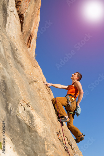 Young male climber hanging by a cliff. © vetal1983