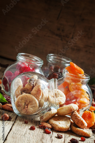 Delicious dried figs in a glass jar on old wooden table, with dr