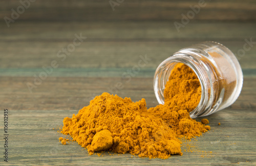 Pile of turmeric in a wooden background
