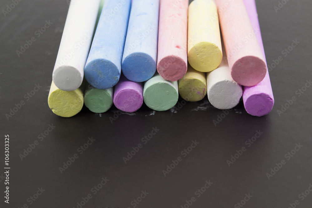 multicolored crayons on a black background
