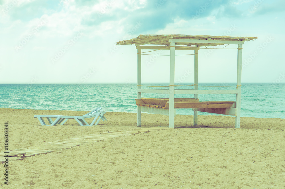 Sunbeds on the empty beach. Foto with retro instagram effect