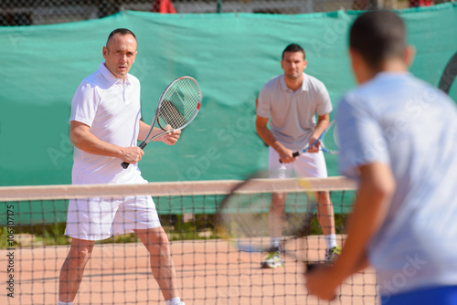 Men playing tennis doubles
