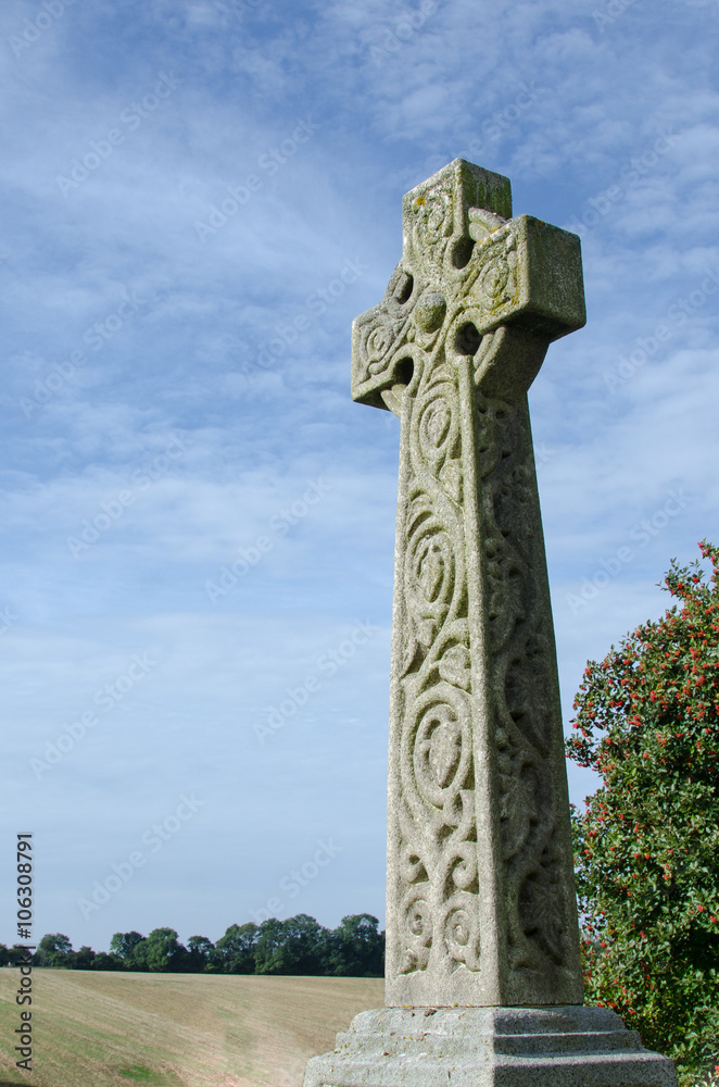 Celtic style cross against a blue sky.