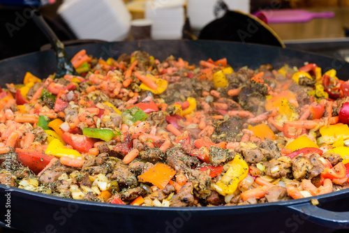 Vegetables with meat in a large pan (small DOF).