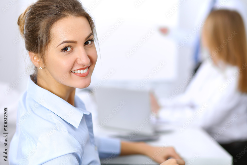 Beautiful business woman on the background of business people during meeting Beautiful business woman on the background of business people during meeting