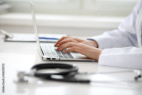 Female doctor typing on laptop  close up