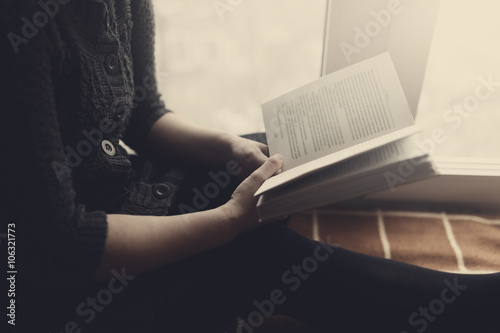 Woman read book seat on the plaid near window