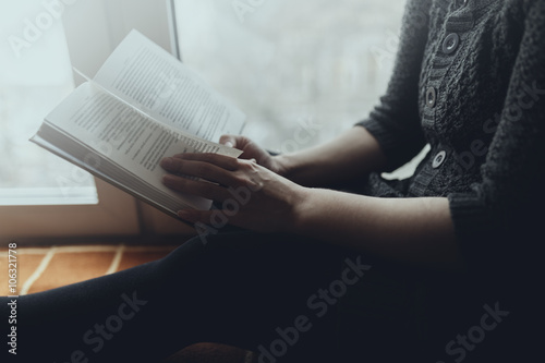 Woman read book seat on the plaid near window