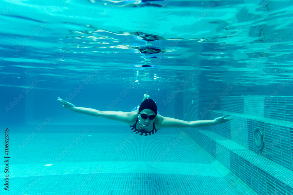 girl swimmimg underwater in pool