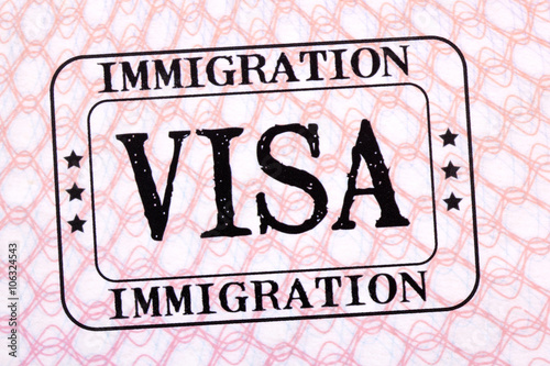Immigration visa rubber stamp on a passport paper page photo