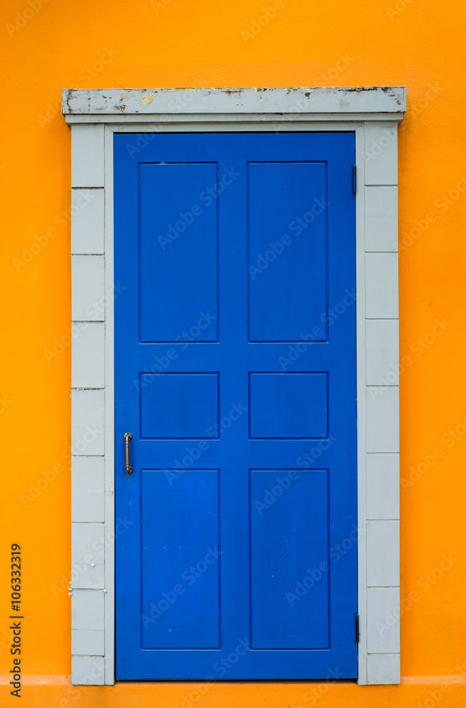 Vintage blue door in bright yellow wall