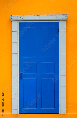 Vintage blue door in bright yellow wall