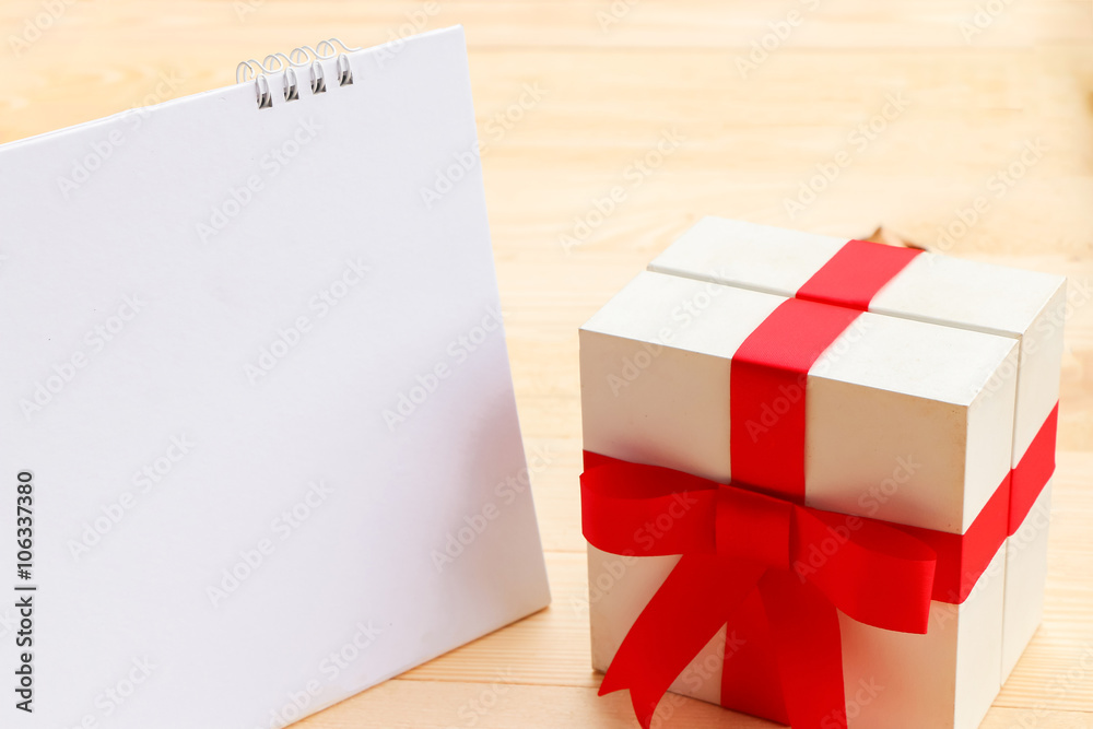 Blank paper with box gift on wooden table use for background Blank paper with box gift on wooden table use for background
