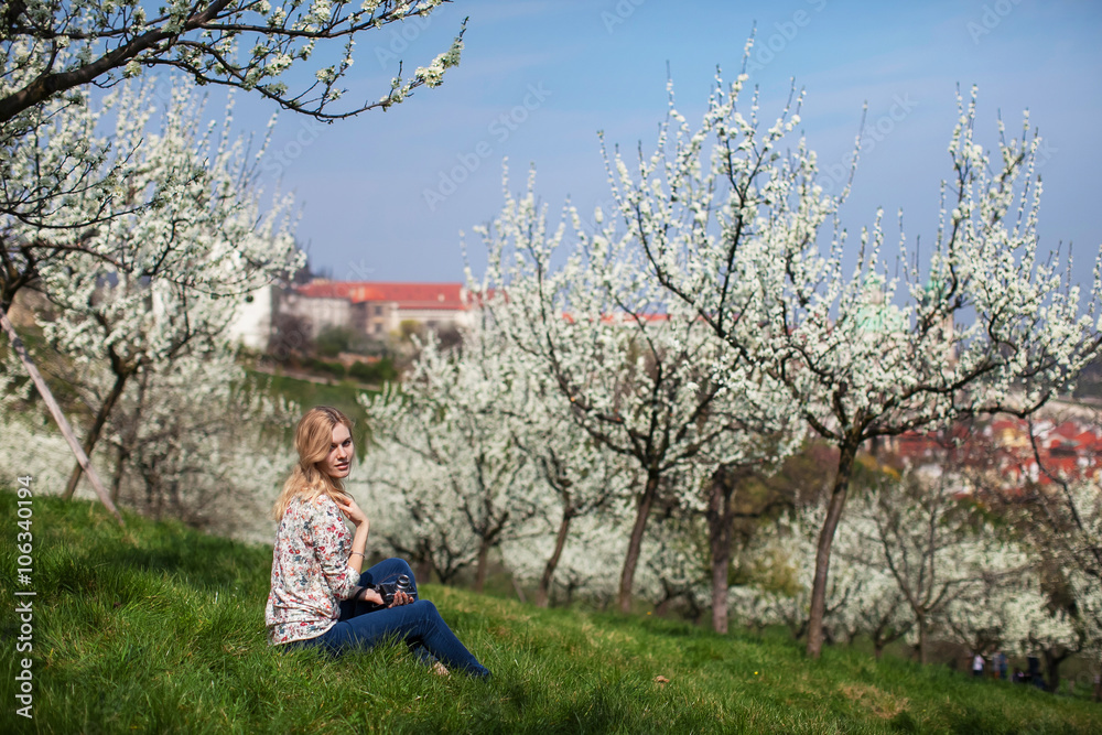 girl with camera is sitting in the garden of blooming apple trees girl with camera is sitting in the garden of blooming apple trees