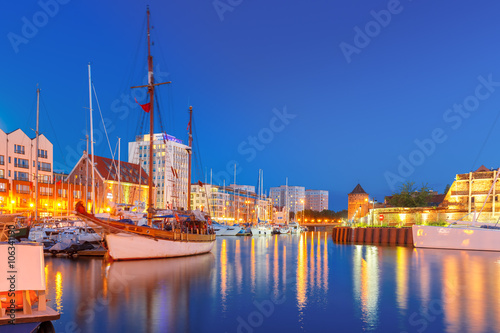 Tourist ships in Harbor at Motlawa river and The Milk Can Gate, Brama Stagiewna at night, Gdansk, Poland