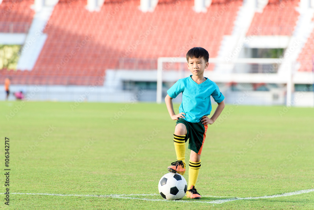 Boy and football in the football grass field