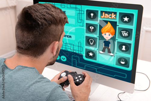 Young man playing computer ...