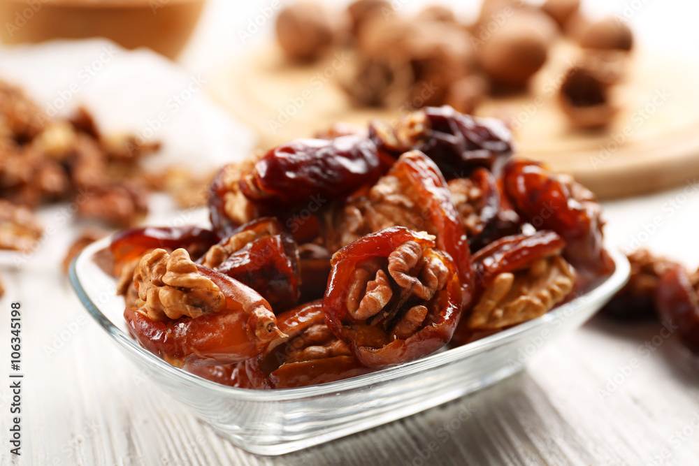 Walnut and date fruit on wooden table, close-up Walnut and date fruit on wooden table, close-up